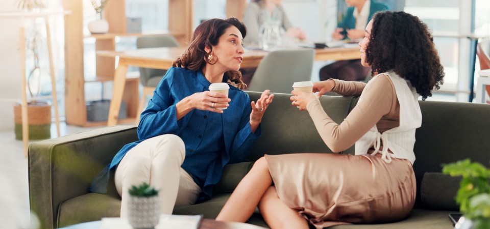 two people talking on a sofa at work
