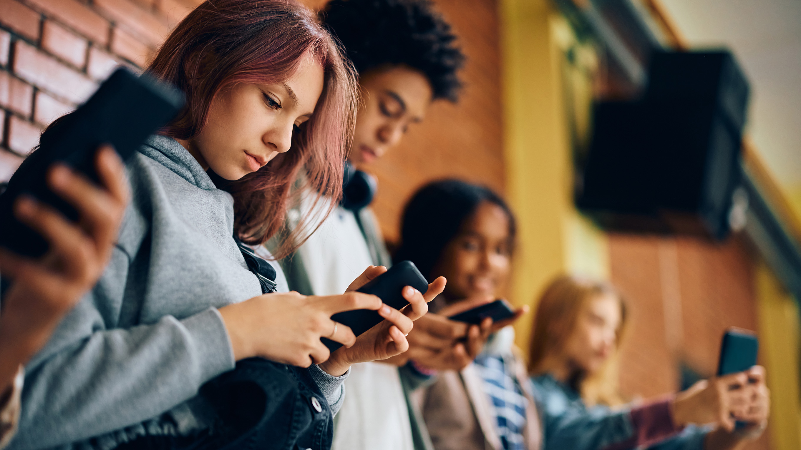 Teenagers stood looking at phones