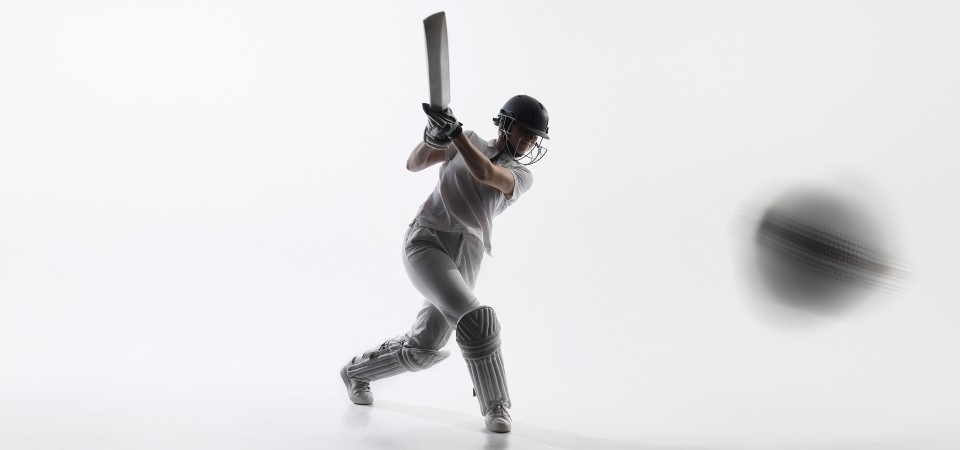 A female cricketer hits the ball