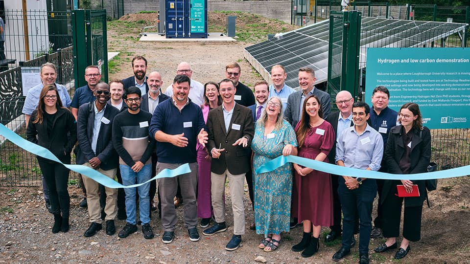 A group of people cutting a ribbon to open the centre all smiling to camera
