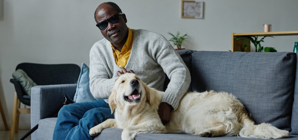 A blind man sitting with his dog