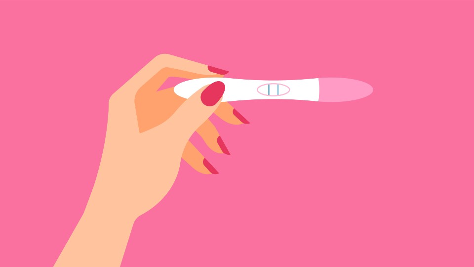 Pink background with a hand holding a pregnancy test