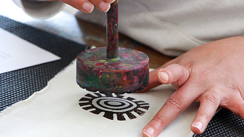 A person printing a pattern on fabric
