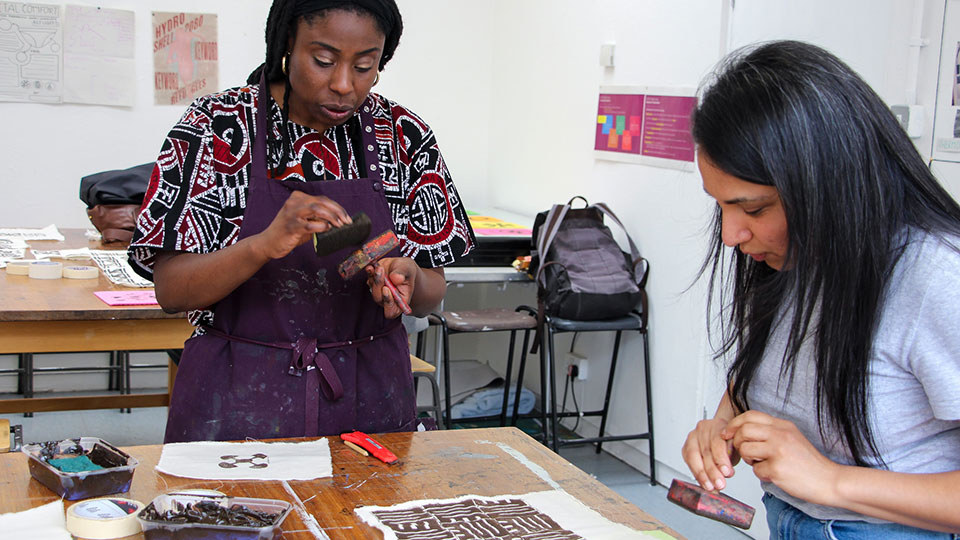 Two people doing textile printing.