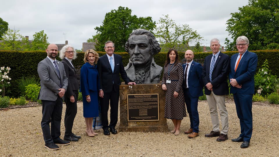 Sam Edwards standing with a group of people around the statue of George Washington