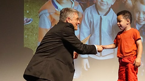 Child receiving certificate at Leavers Graduation