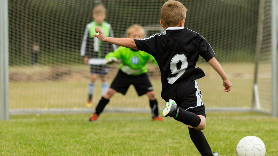 A young person kicking a ball