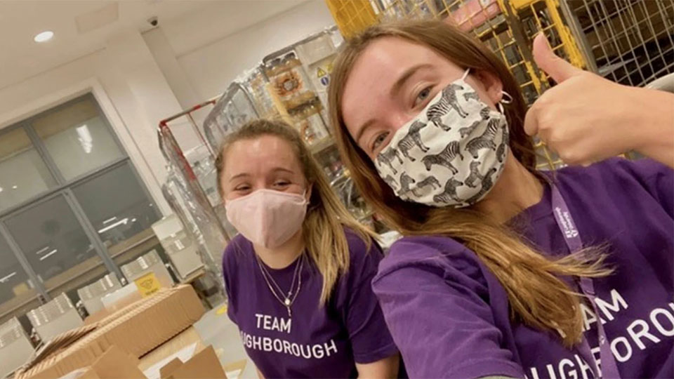 Two students in purple tee-shirts wearing face coverings