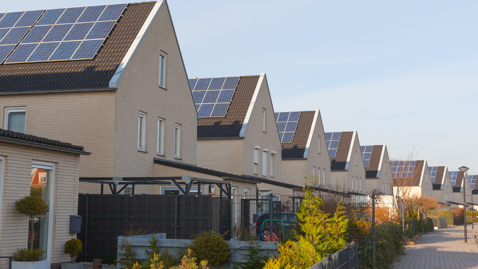 A row of modern houses with PV panels on their roofs