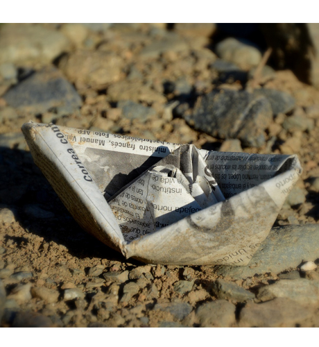 Close up photograph of a boat crafted from newspaper