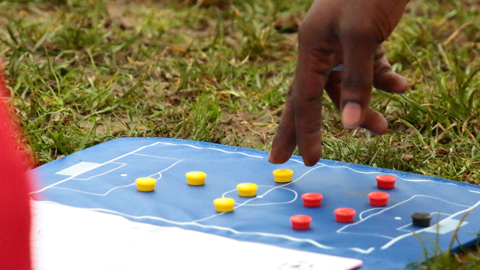 Hand hovering above pitch diagram, discussing strategy