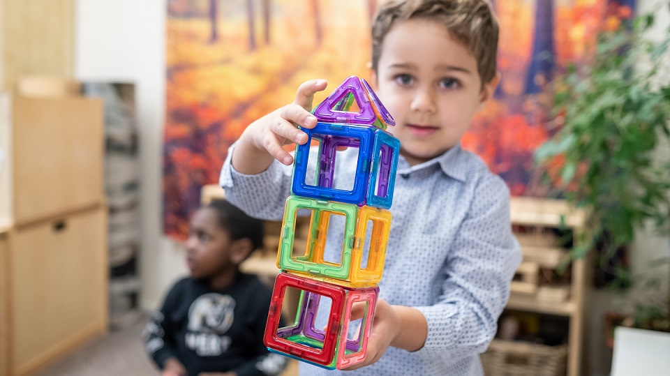 young boy holding a toy structure