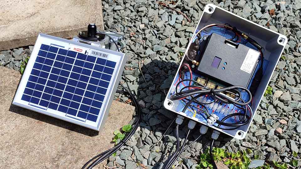 Solar panel and sensors wired to a data-logging electronic control box taken from an aerial view.