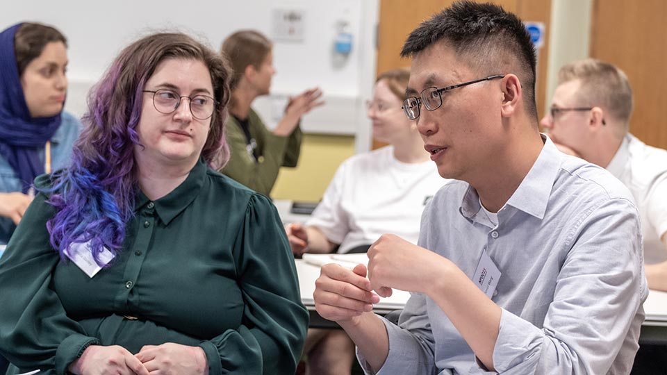 Two attendees in conversation at the C-DICE postdoc conference