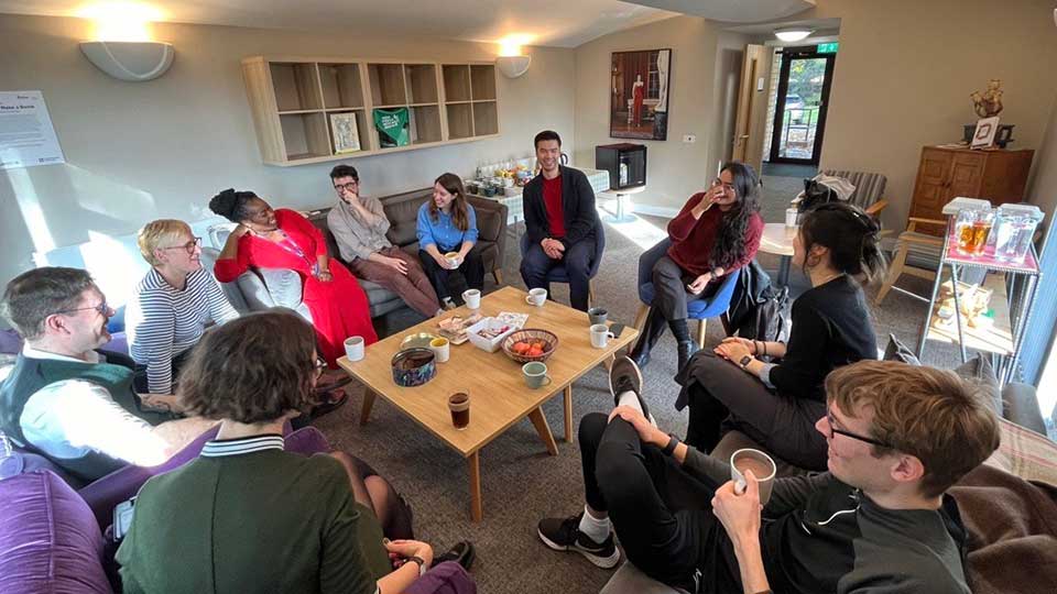A group of people speaking over coffee