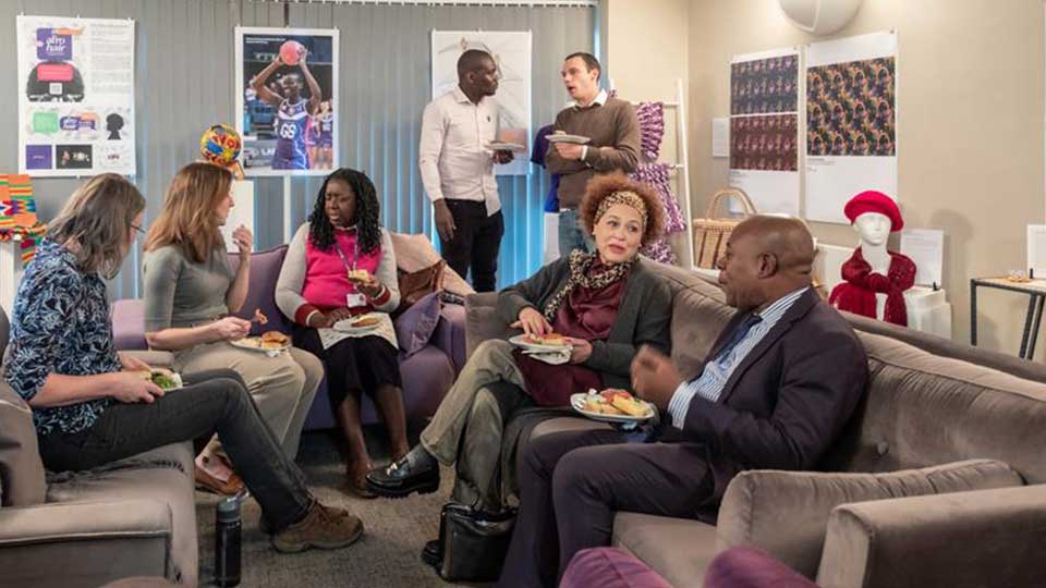 A group of people sat talking surrounded by artefacts