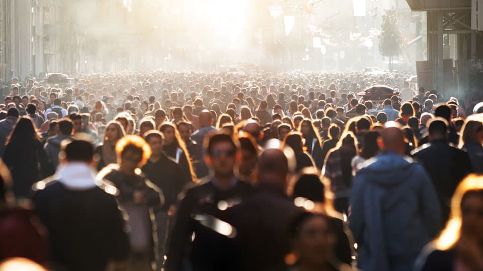 a crowded street with low sunshine