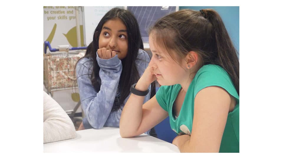 two members of the Frenzy Youth Theatre sitting resting their chin in their hand