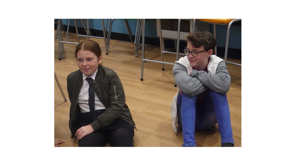 two theatre members sitting on the floor