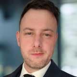 Professional headshot of Alun in a suit