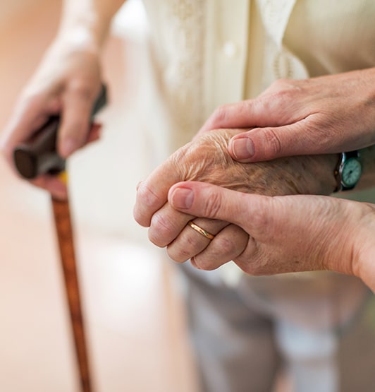 Nurse holding elderly patient's hand