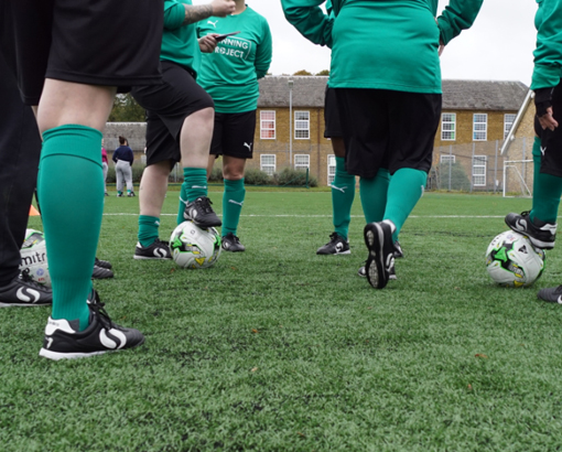 Young football players in conversation with their coach