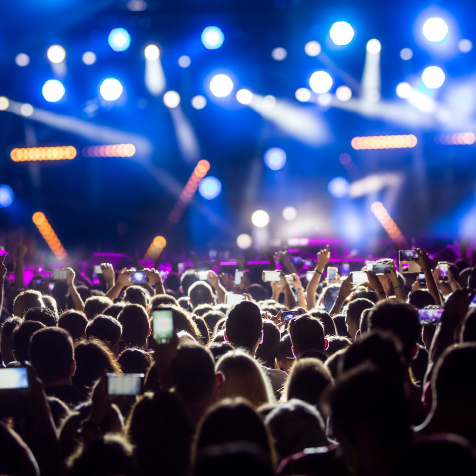 Photograph of a crowd at a gig, recording and photographing the band with their phones