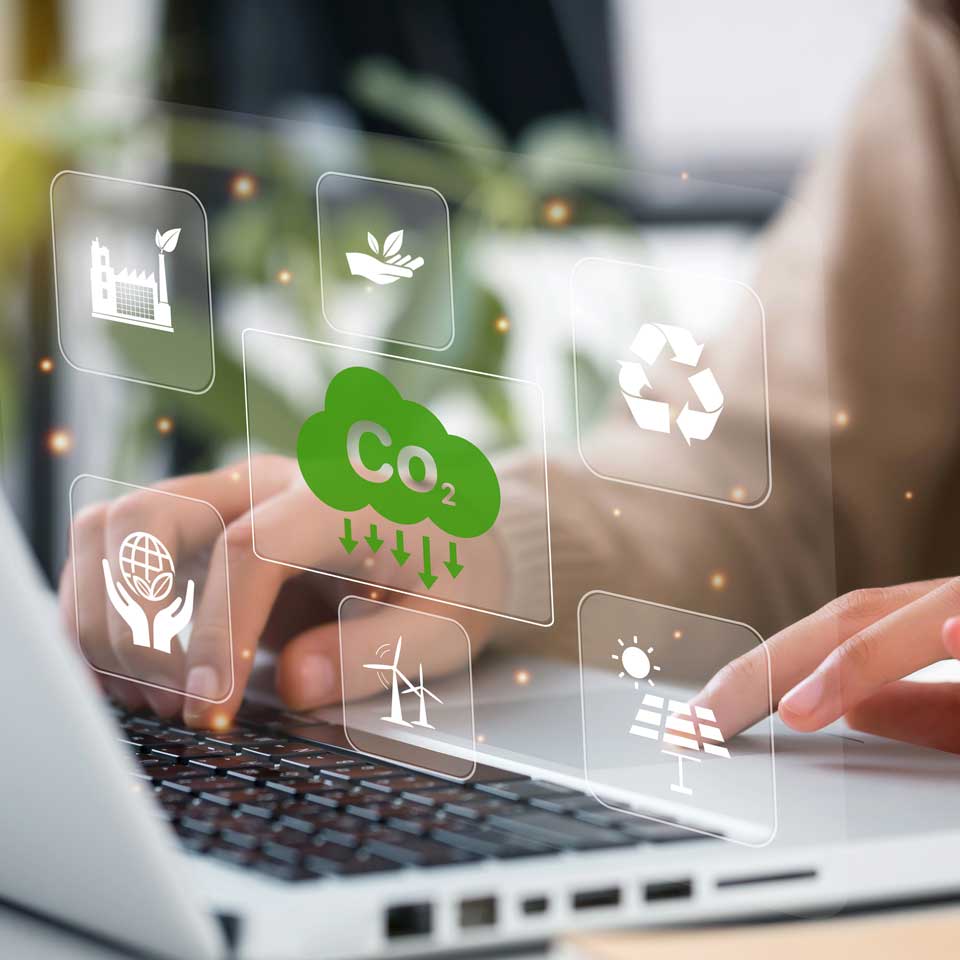 Close up photograph of someone using a laptop, superimposed with symbols suggesting green energy