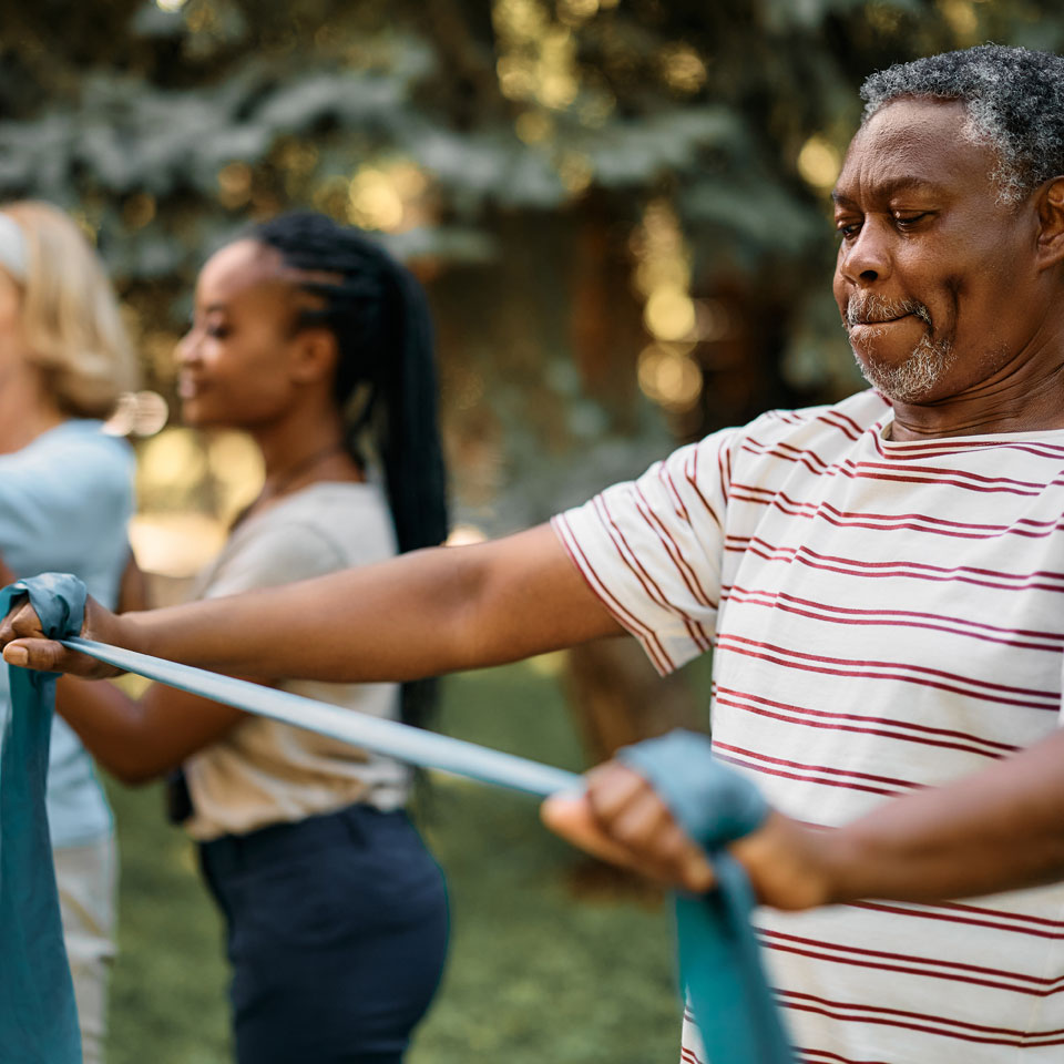 An older person using a resistance band during an exercise class