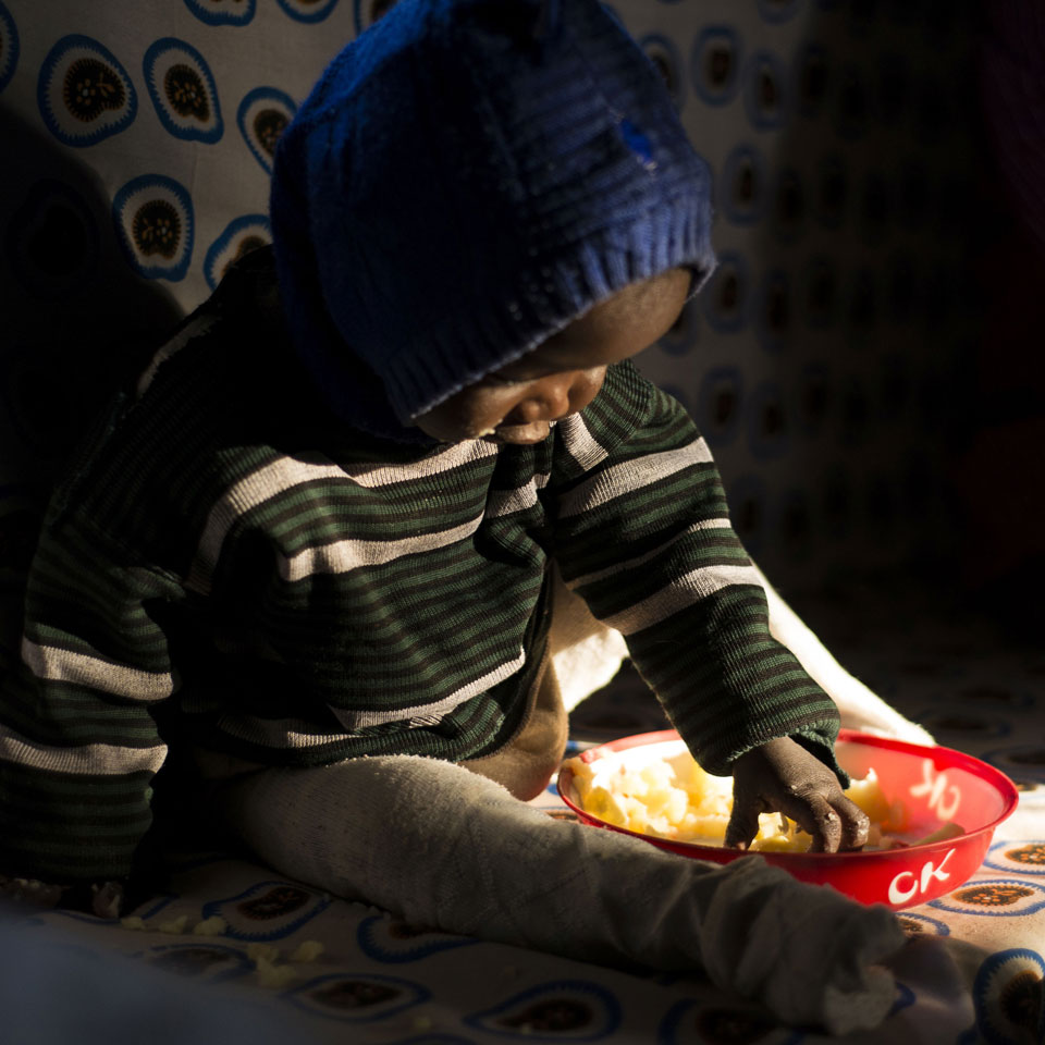 A young child self-feeding (BFCI, Kenya)