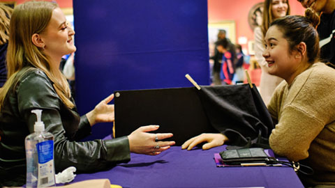 Scientist taking a visitor through one of the hand illusions