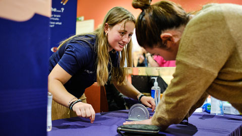 Scientist taking a visitor through one of the hand illusions