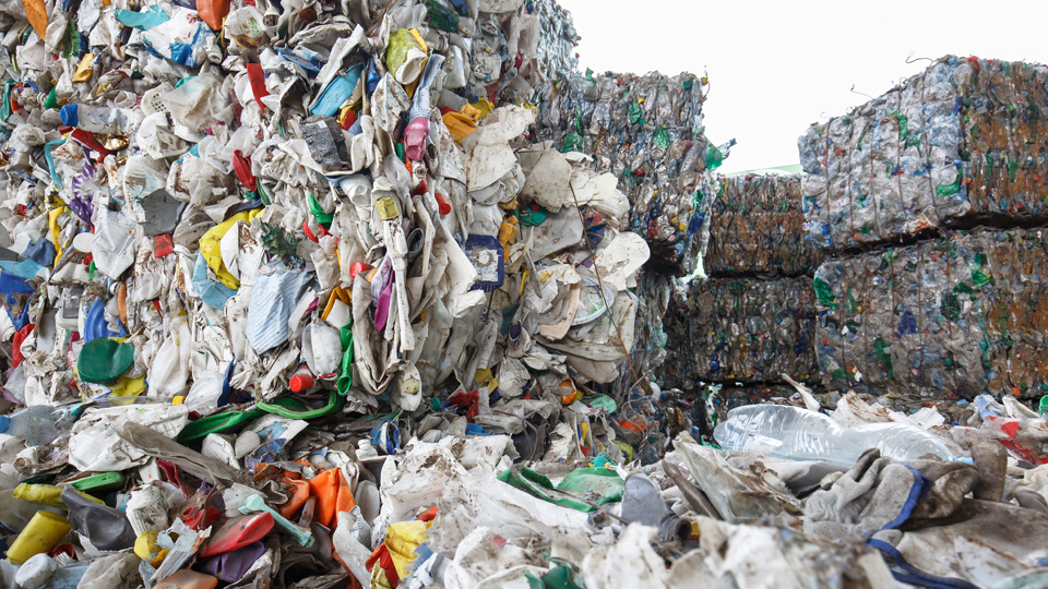 Photograph of a mountain of plastic waste, baled for recycling.