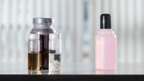 A flask of fermentation broth beside a bottle of nail varnish remover