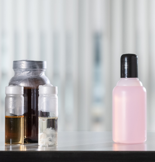 Photograph of the raw ingredients of nail varnish remover with a bottle of the product