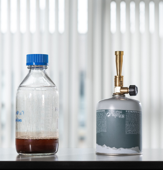 A flask of wastewater beside a gas cannister