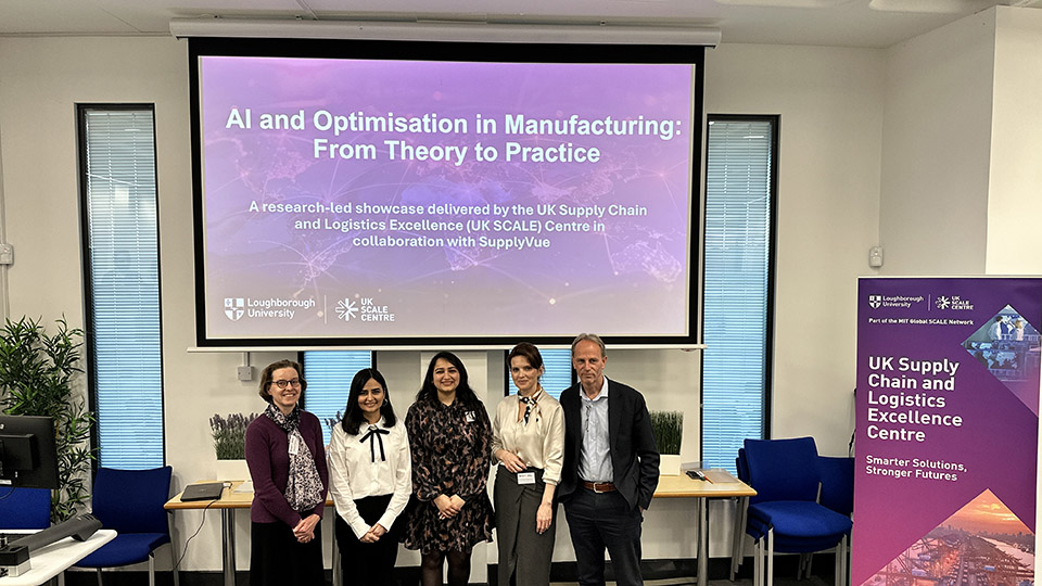 Group of speakers standing in front of a presentation screen at a UK SCALE Centre event titled “AI and Optimisation in Manufacturing: From Theory to Practice,” held at Loughborough University.