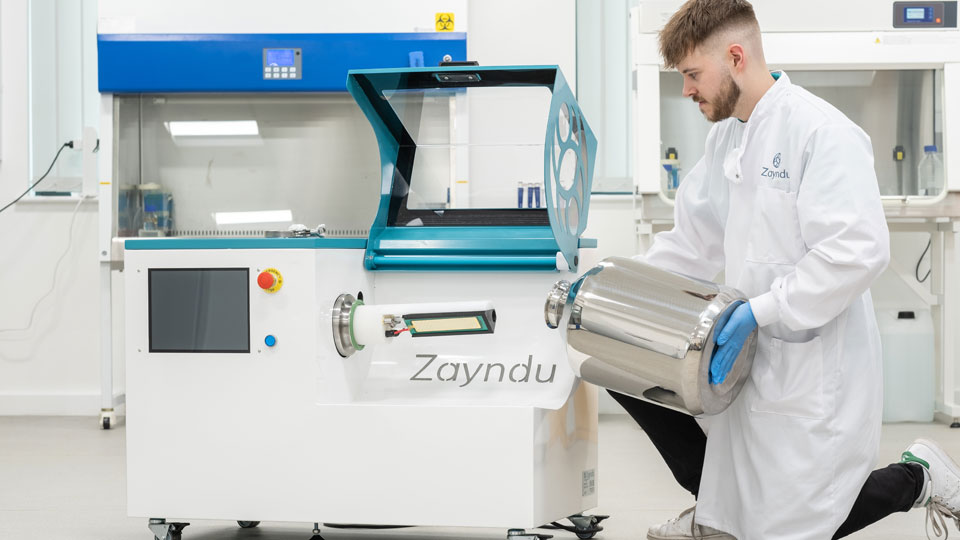 A technician kneeling beside the Zayndu technology, preparing it for seed sterilisation