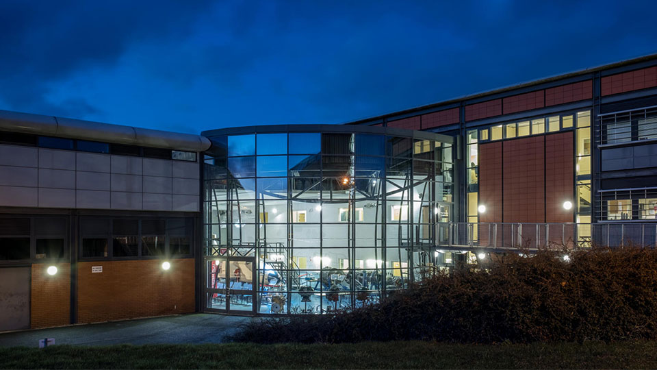 the Stewart Miller building with lights on at night