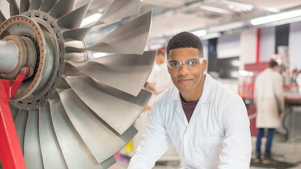 a student next to an aircraft engine