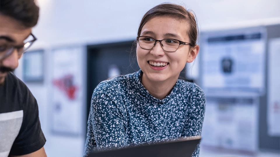 image of AAE student smiling wearing glasses and a floral top
