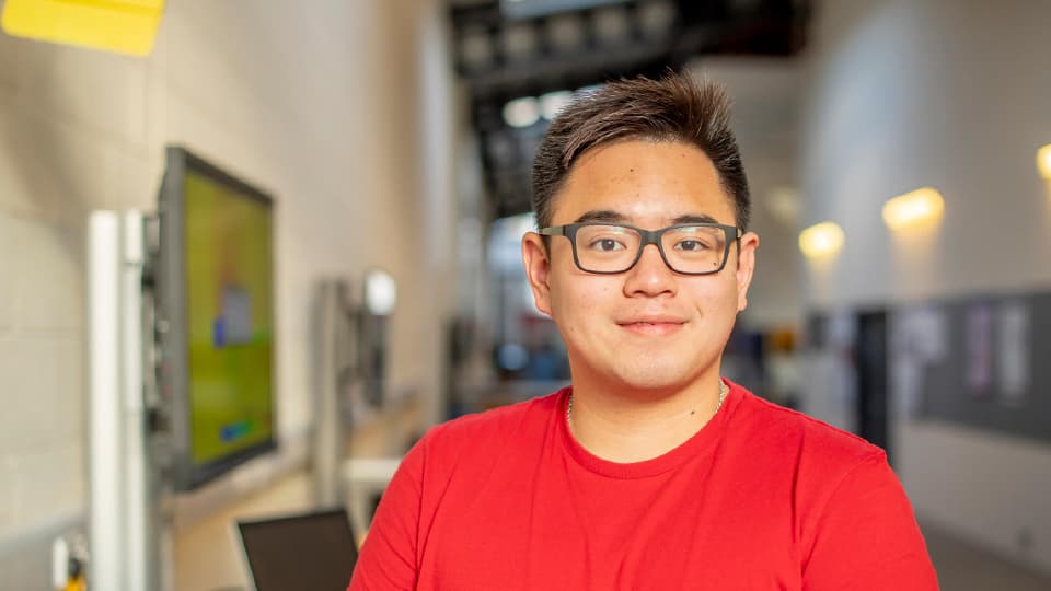 Image of student, Ken, standing in the corridor.