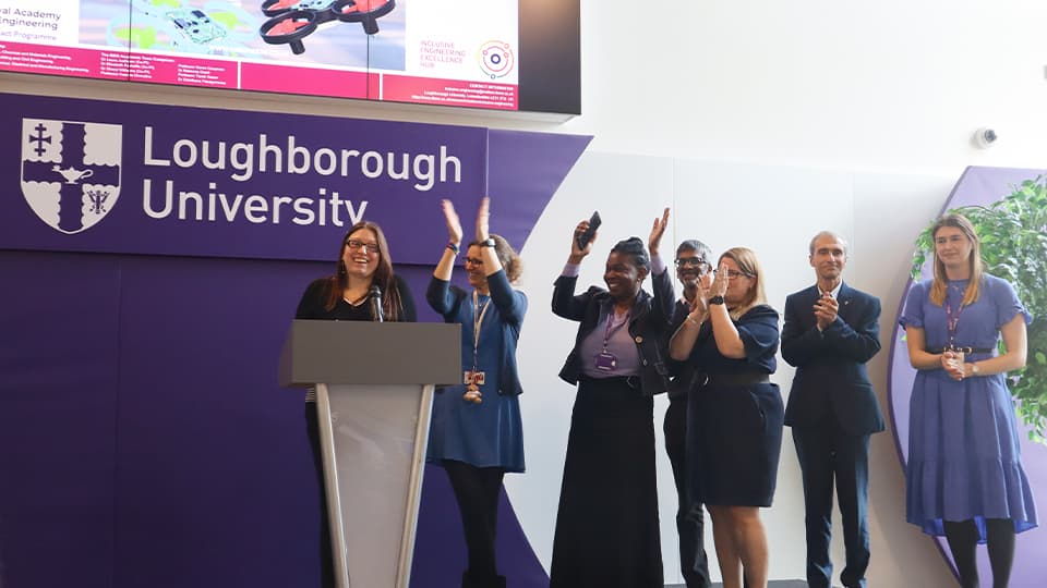 group of academics on stage clapping