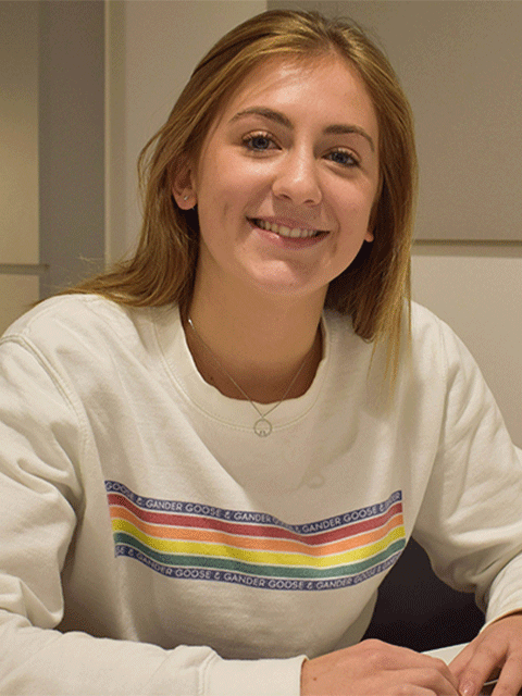 female student smiling in white jumper