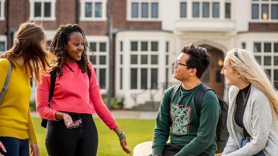 A group of students chatting at the fountain on campus.