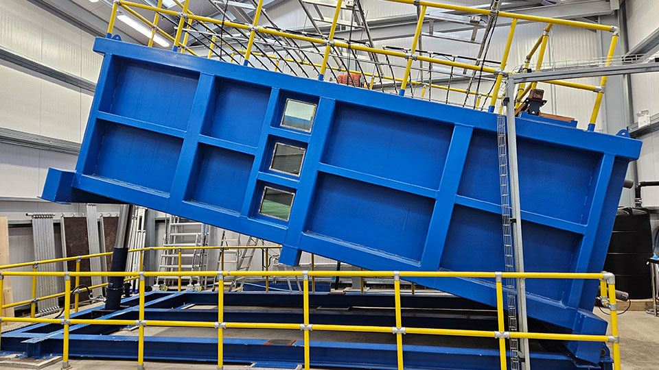 the National Engineered Slope Simulator (NESS), which is a 15-tonne steel box (6m long, 3m wide, 2m tall) that can be filled with 45 tonnes of compacted soil, then rotated to create a slope, and then subjected to simulated weather patterns
