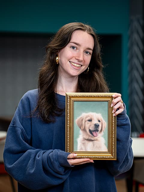 Beth Harrison holding her artwork