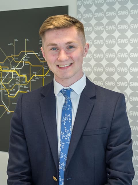 A placement student wearing a suit smiling towards camera.