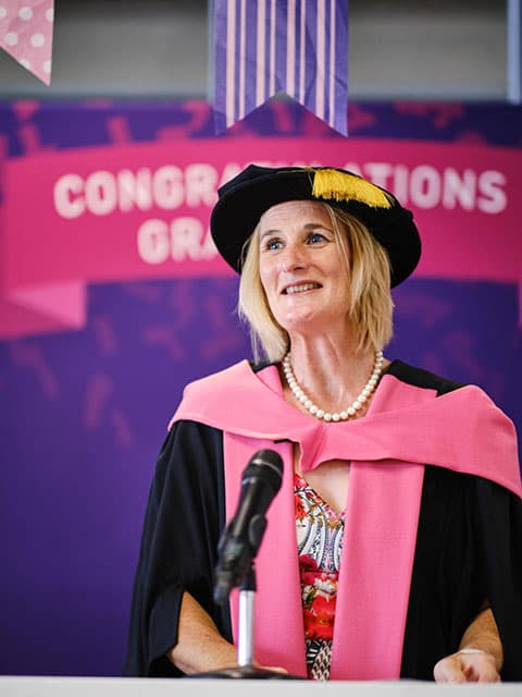 Jan Godsell giving a speech at a graduation celebration event.