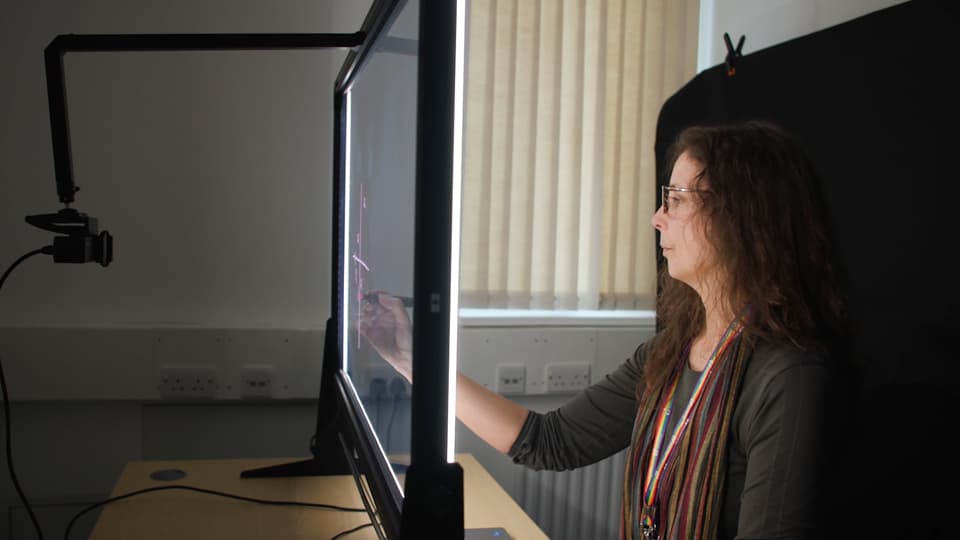 Professor Vikki Locke draws on the interactive 'Lightboard'.